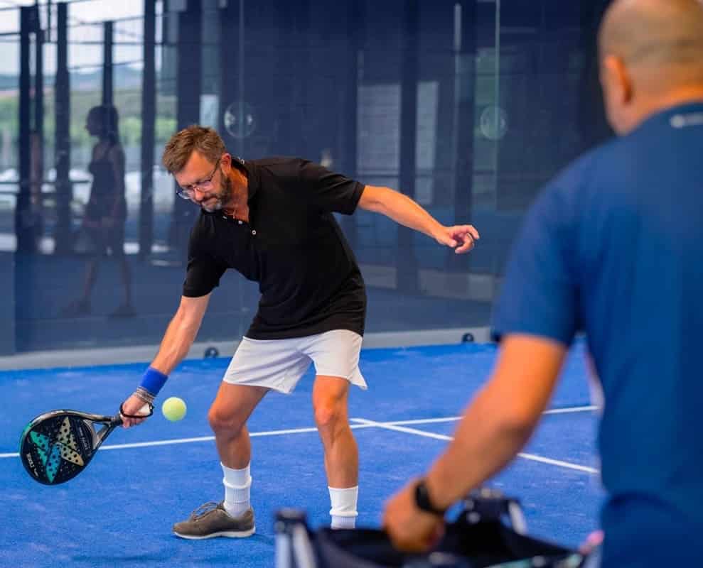 Niveau padel avec débutant progressant sur terrain