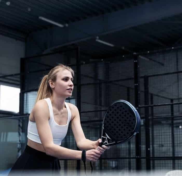 Niveau padel avec joueuse sur le terrain en action